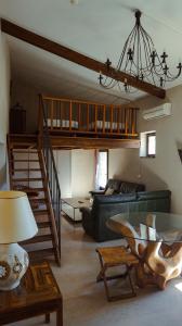 - un salon avec un canapé et un escalier dans l'établissement Hôtel la Fête en Provence, à Vaison-la-Romaine