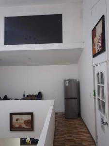 a living room with a television and a refrigerator at Hostal Pura Vida in Santiago