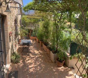 a patio with a table and some trees and plants at La casina delle rondini in Corsanico-Bargecchia