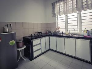 a kitchen with a sink and a refrigerator at JAZZ HOMESTAY JASIN BESTARI MELAKA in Kampong Bemban