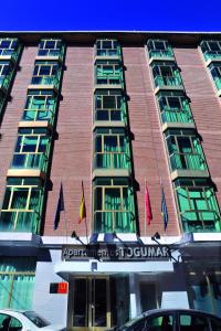 un grand bâtiment avec des drapeaux devant lui dans l'établissement Sercotel Togumar, à Madrid