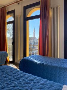 a bedroom with two beds and a window with a view at Ostello di Vicenza in Vicenza