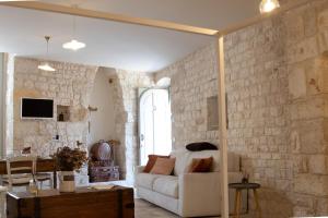 a living room with a white couch and a brick wall at Dimore Storiche Casalnuovo in Conversano