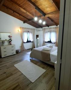 ein Schlafzimmer mit einem großen Bett und Holzböden in der Unterkunft La Corte Liberty Rosa in Iglesias