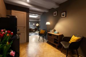 a living room with chairs and a desk and a table at Stanley Collection Hotel Hegra Amsterdam in Amsterdam