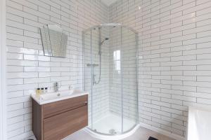 a white bathroom with a shower and a sink at Stylish 2-bed Duplex Stunning Malvern views Peaceful Getaway in Malvern Wells +14 photos