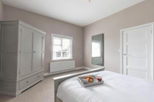 a bedroom with a bed and a dresser with a teddy bear on top at Vaughan Lodge- Stunning 2 Bedroom Duplex Apartment in Malvern Wells