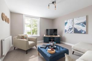 a living room with a blue couch and a tv at Stylish 2-bed Duplex Stunning Malvern views Peaceful Getaway in Malvern Wells