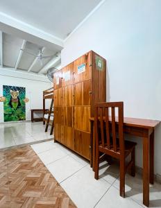 Habitación con escritorio de madera y armario de madera. en El Mural Backpackers, en Tarapoto
