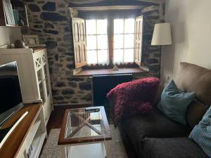 a living room with a couch and a glass table at Casa Lici in Robles de Laciana