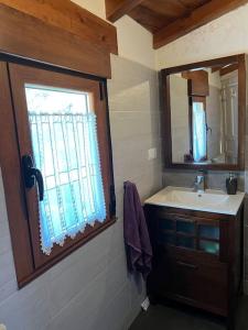 a bathroom with a sink and a window at Casa Lici in Robles de Laciana +6 photos