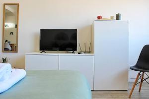 ein weißer Schrank mit einem Fernseher darüber in der Unterkunft Plano C 2 Oporto Downtown in Porto