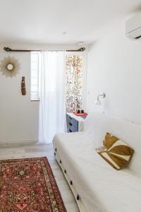 een witte slaapkamer met een bed en een raam bij The Feel Good at the beachside in La Ciotat