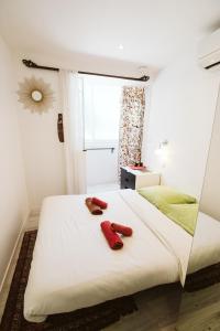 een slaapkamer met 2 rode handdoeken op een bed bij The Feel Good at the beachside in La Ciotat