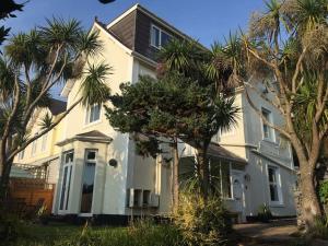 una casa bianca con palme di fronte di Strawberry Fields - CENTRAL TORQUAY a Torquay