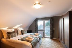 a bedroom with a large bed with a large window at Haus Cervus in Hattgenstein