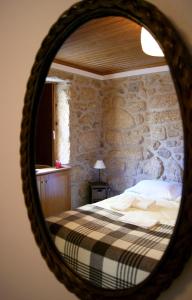 a bedroom with a bed and a stone wall at Cantinho Santiago in Belmonte