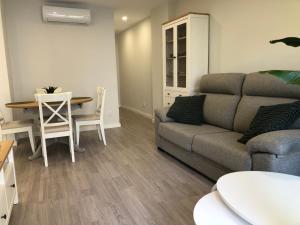 uma sala de estar com um sofá e uma mesa em Apartamento Vicaño - PLAYA SILGAR em Sanxenxo