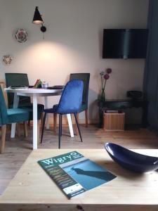 a dining room with a table and blue chairs at Apartamenty Zielone Drzwi in Kruklanki