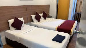 two beds in a hotel room with two at ESM Hotel in Tanah Rata