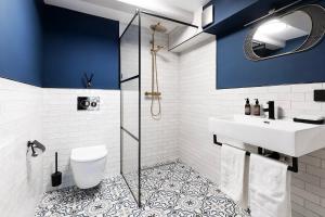 La salle de bains est pourvue de murs bleus, d'un lavabo et de toilettes. dans l'établissement Stanley Collection Hotel Hegra Amsterdam, à Amsterdam