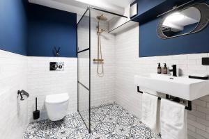 ein Badezimmer mit blauen Wänden, einem Waschbecken und einem WC in der Unterkunft HEGRA by Stanley Collection in Amsterdam