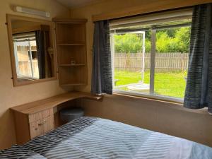 Schlafzimmer mit einem Bett und einem Fenster in der Unterkunft Ferien Tiny Haus am Waldrand in Bad Ischl