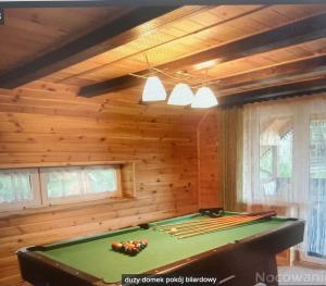 a pool table in a room with wooden walls at Mazurówka Romana in Spychowo