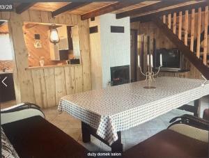 a dining room with a table and a fireplace at Mazurówka Romana in Spychowo