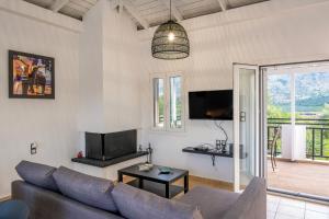 een woonkamer met een bank en een tv bij Villa Eirini Lake Kournas Chania in Mouríon