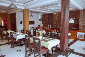 a restaurant with tables and chairs in a room at Capitole Hotel in Abidjan