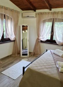 Schlafzimmer mit einem Bett und einem Spiegel in der Unterkunft La Corte Liberty Rosa in Iglesias