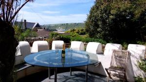 a glass table and chairs on a patio at Bantham House, Bantham, South Devon - a few steps from golden sandy beaches in Bigbury on Sea