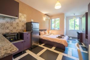a small room with a bed and a refrigerator at Spacious apartment in the heart of Studentski grad in Sofia