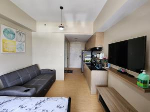 a living room with a couch and a flat screen tv at Sunvida Tower Condominium across SM Cebu City in Cebu City