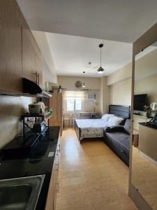 a kitchen and living room with a bed and a couch at Sunvida Tower Condominium across SM Cebu City in Cebu City