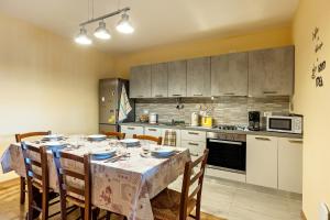 a kitchen with a table with chairs and a table cloth at Cascina Raperonzolo in Lonato del Garda +6 photos