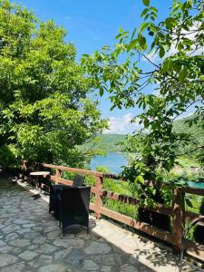 um banco e uma cerca com vista para um lago em Apartment with river Una view / Ilma 2 em Bihać
