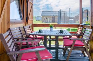 ein Tisch und Stühle auf einer Veranda mit einem Fenster in der Unterkunft Domki Redda in Kopań