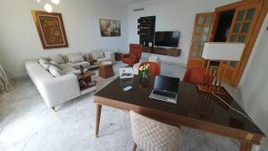 Tunis medina في تونس: غرفة معيشة مع مكتب مع لاب توب عليه