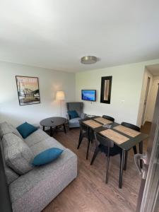 un salon avec un canapé et une table dans l'établissement L'Ecrin d'Edern 4pers Mont Dore, à Le Mont-Dore