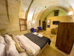 a bedroom with a bed in a stone room at Heritage Cave Suites in Ürgüp