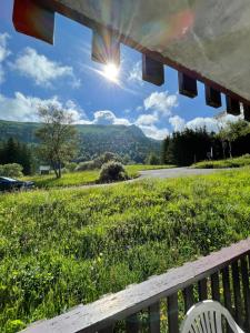 une vue d'un champ avec un banc et le soleil dans l'établissement L'Ecrin d'Edern 4pers Mont Dore, à Le Mont-Dore 11 autres photos