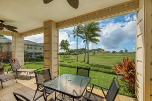 a patio with a table and chairs and a view of a golf course at Pili Mai 10F in Kipu
