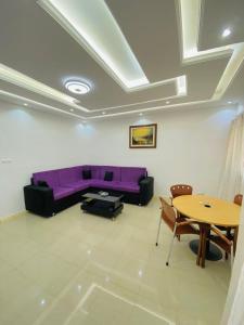 a living room with a purple couch and a table at Appartement xandra in Dakar