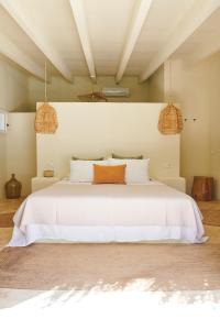 a bedroom with a white bed with two pendant lights at Agroturismo Can Domo in Santa Eularia des Riu