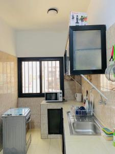a kitchen with a sink and a microwave at Appartement xandra in Dakar