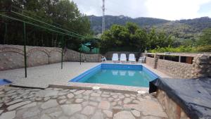 a swimming pool in a yard with chairs around it at Los rosales in Burunchel