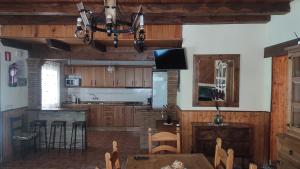 a kitchen with wooden cabinets and a table and a chandelier at Los rosales in Burunchel