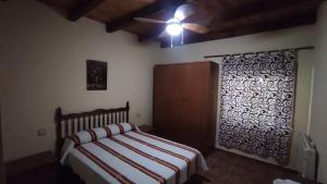 a bedroom with a bed and a ceiling fan at Los rosales in Burunchel